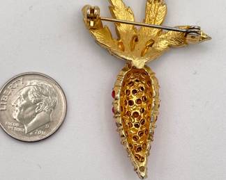 Reverse of vintage gold tone and enamel carrot brooch with vibrant deep orange rhinestones