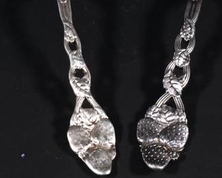 Closeup of sterling silver large serving spoons with berry finial handles - one marked Tiffany & Co. Sterling