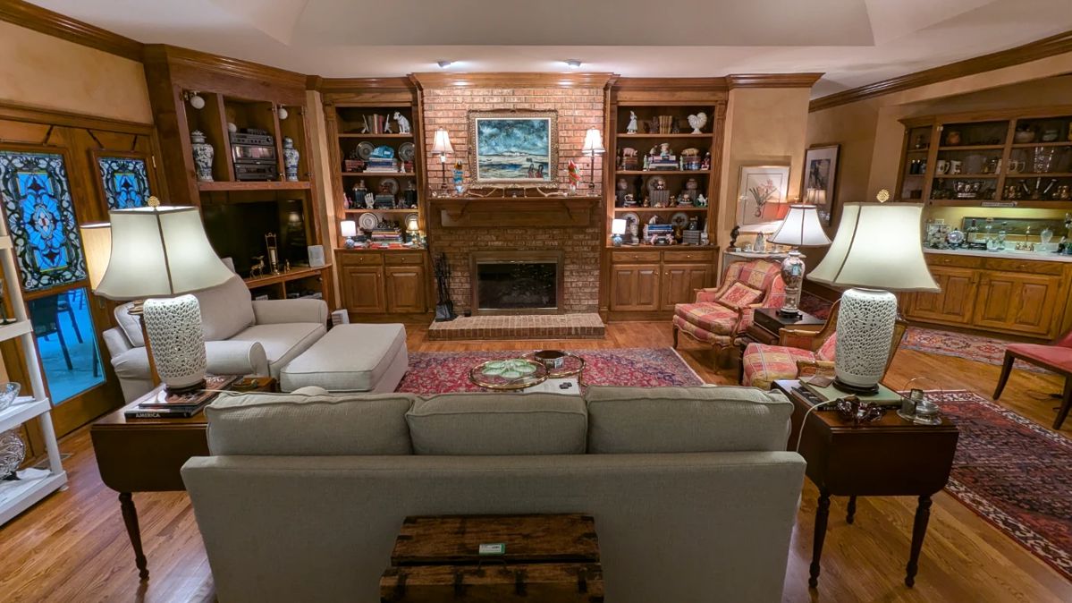 Great room with sofa and matching loveseat/ottoman, by Cindy Crawford Home, pair of 1930's mahogany two-drawer drop-leaf side table, by Biggs Furn. Co., (Richmond, VA), pair of white porcelain Asian table lamps, vintage, hand-woven Persian rugs, bookcases full of vintage books and cast iron collection and pair of 1930's mahogany two-drawer drop-leaf side table, by Biggs Furn. Co., (Richmond, VA), pair of matching stained glass panels.