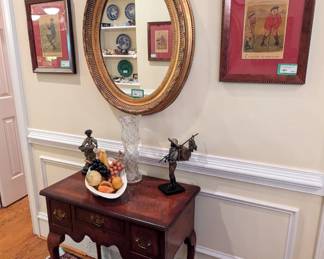 Antique English burled wood 3-drawer desk, w/large antique American brilliant cut glass vase, pair of bronze statues and 1950's ceramic cornucopia, w/stone fruit, one of a pair of vintage gilt wood oval mirrors, pair of framed, antique English magazine ads and set of 3 hand-painted floral plates, England. 