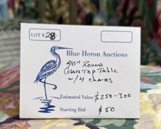 Lot #28: Iron and wicker glass topped table with four floral upholstered Parsons chairs on casters