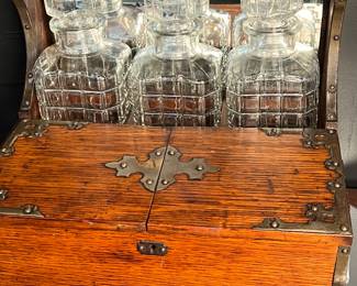 Lot #27: Antique English Oak Tantalus Box with hammered brass accents and three intact original glass decanter with stoppers