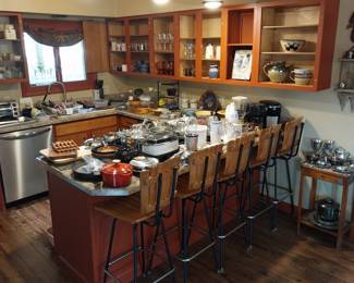 Mid Century bar stools, Pyrex, silver tea set, Hamilton Beach microwave, Calphalon pots and pans, Aikido knife set, Keurig, Proctor Silex coffee pot, Sunbeam mixer, Magic Bullet, Le Cruset measuring cups and spatulas, Cowboy “cold handle” frying pan