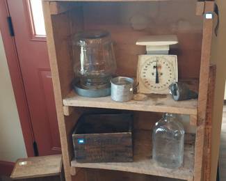 primitive shelving, crates and boxes, yard sticks, basket, milk bottle