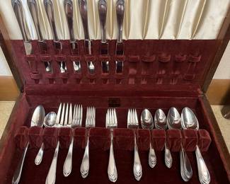 Several sets of silver plate flatware.