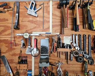 Organized hammers and wrenches hanging on wall