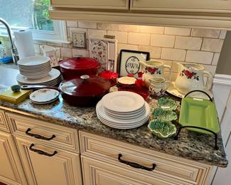 Red dutch oven and red enamel pan with lid, white Phaltzgraff plates, vintage "Poppy Seed" pitchers
