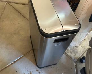 Simple human trash can holds two bins for trash and recycle