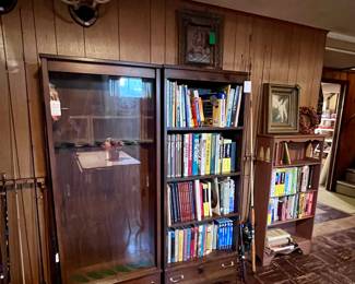 Gun cabinet, bookshelves, books.