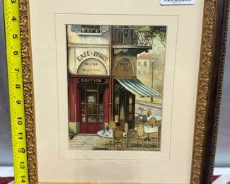 Retail $50. Our Price: $20. Charming framed print of a Parisian cafe scene, measuring 12x15 inches with an ornate gold frame.