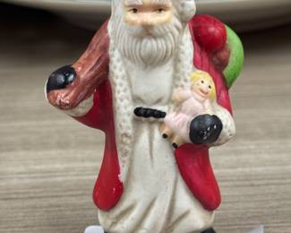 Our Price: $1. Vintage Santa Claus Ornament. Charming Santa ornament holding a doll, perfect for holiday decorating.