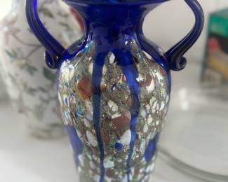 Our Price: $250. Cobalt Blue Murano Glass Vase with Multicolored Inclusions. This exquisite 11.5” vase showcases traditional Venetian craftsmanship with vibrant colors and intricate details. Made in Italy