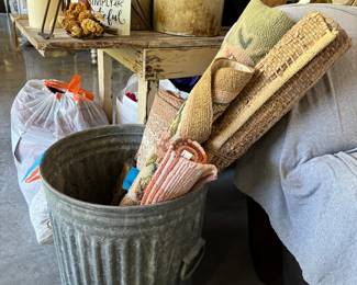 Galvanized trash can and various throw rugs