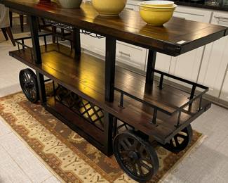 This large bar cart/island/work station is easily movable with solid cast iron wheels