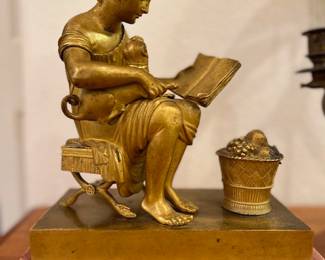 Cast Bronze Sculpture, seated girl reading with a lap dog, basket of fruit at feet, unsigned, 8 1/2 x 9 x 4 1/2 inches, circa late 19th century.
