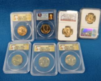 Lot 199. Five Sacagawea gold-colored Dollar Coins and Two Gold-Colored Presidential Dollar Coins.