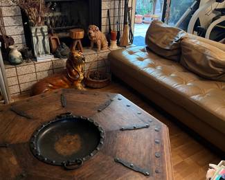 Leather sofa, wood round coffee table, ceramic statues.