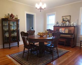 Antique quarter sawn oak table, antique curio cabinet, and upright piano