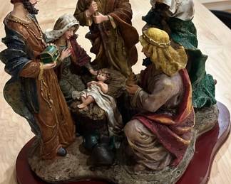 Large vintage resin nativity scene on a wooden pedestal.  Size is 12 inches high by 16 inches wide.
