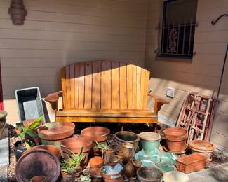 Large outdoor wooden bench, live plants, gardening pots