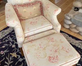 Upholstered armchair with ottoman.