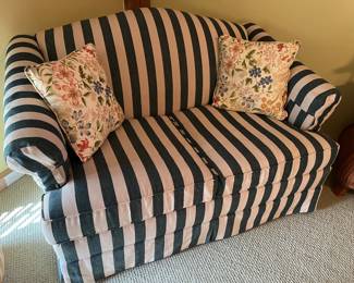 Green-and-white-striped loveseat hide-a-bed.