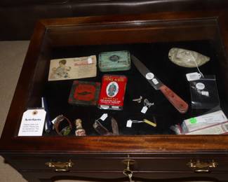 Vintage smalls inside of a table in front of leather sofa,  Den