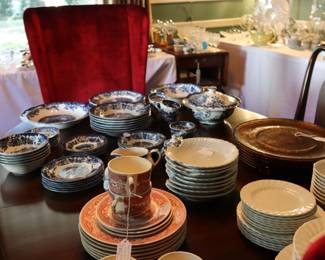 Dining table topped with china, red velvet host and hostess chairs, DR