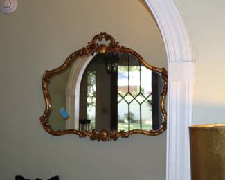 Gilt, ornate mirror in back of entrance hall