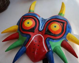 Colorful mask made by the Scriber's daughter, just in time for the season. On the table with other costumes. 