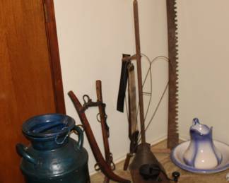 Old painted milk can, wooden harness, butter churner, saw, rug beater, wood coffee grinder, pitcher and bowl