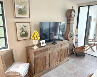 natural finish wood console, flat screen TV, painted Swedish standing clock (antique, but nonfuctional) with tin face