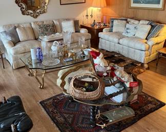This living room shows a sofa and love seat in the back, behind the two coffee tables and the one floor rug.  