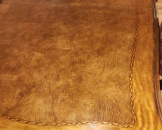 Henredon dining table with two 18" leaves and pads.  Elephant head/trunk style legs.  Pictured with 10 chairs by Century.    Top detail