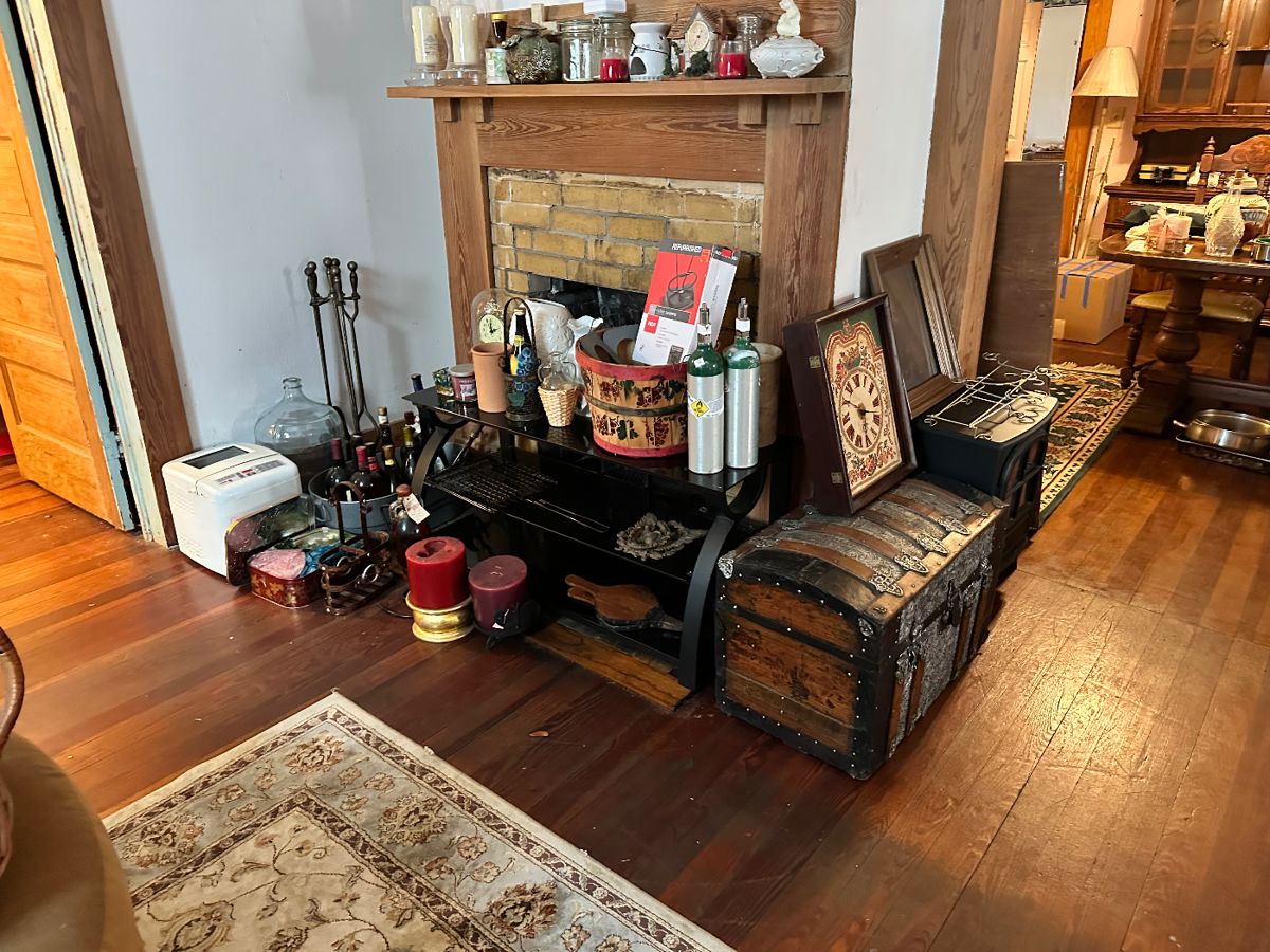 Trunk clock, candles, bread machine, fireplace kit, TV stand, various home decor, a small electric fireplace
