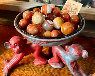 Antique banded and corkscrew carnelian marbles in a retro enameled monkey dish