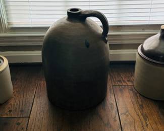 Far Left 1) Antique Stoneware Jug w/ Handle and Cork - $50. 2) Antique Stoneware Jug $100. 3) Vintage Stoneware Crock with Brown Jug Lid - $50

