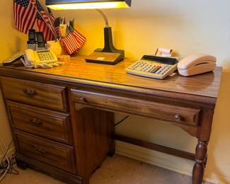 Wood desk and drawers, reading light, vintage calculator, AT&T landline phones, US Flags