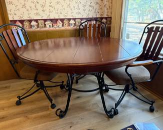Stylish Wood and Metal Kitchen Table with Four Matching Chairs (three shown). This modern, industrial-inspired set features a sturdy wood tabletop with a sleek metal frame, combining durability with a contemporary look