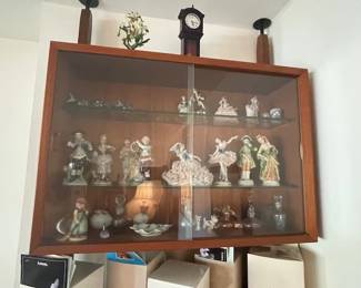 Covered curio shelf with ceramic collectibles.