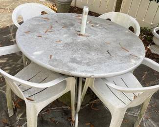 Patio table and four plastic chairs.