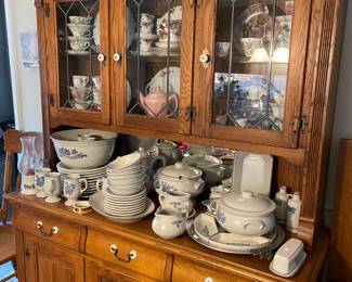 . . . oak lead-glass china hutch filled with English cups and saucers and Yorktown Pfaltzgraff stoneware china