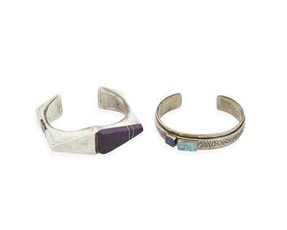 294
Two Southwest silver and stone set bracelets
Late 20th/21st century
Two works:

Danny Romero (1954-2018; Yaqui/Spanish)
Stamped: D R.MER. / FINE / [pictograph]
A chunky modernist sterling silver cuff with inset and inlaid sugalite and mother of pearl
6" inner C x 3/4" H, with a 1" gap

George and Nusie Henry (b. 20th century; Navajo/Diné)
Stamped: G.N.H. / Sterling
A slim sterling silver cuff with a central tufa-cast band and set turquoise and lapis lazuli
6 1/4" inner C x 1/2" H, with a 1" gap

2 pieces
91.2 grams gross
Estimate: $500 - $700