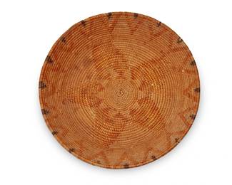 122
A California Mission polychrome basket
Early 20th century; Southern California
The coiled basketry low bowl with central yellow star motif and yellow and banded brown sawtooth motifs at the rim
2" H x 10.875" Dia.
Estimate: $400 - $600