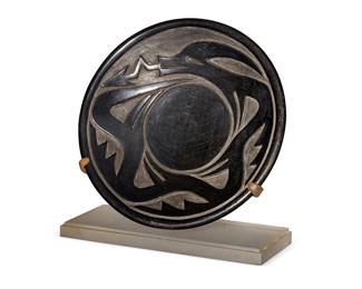 258
Severa Tafoya (1890-1973, Santa Clara Pueblo)
A blackware pottery avanyu plate, mid-20th century
Incised to underside: Severa
The plate with deeply carved avanyu figure in relief, set on a felt-padded acrylic stand
Plate: 2" H x 10.5" Dia.; Stand: 7.25" H x 10.5" W x 4.5" D
Estimate: $400 - $600
