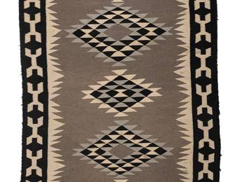198
A Navajo regional rug
Mid-20th century, Diné
Woven in black, grey, and cream wool depicting five serrated diamonds within an elaborate border
70" H x 42" W
Estimate: $500 - $700