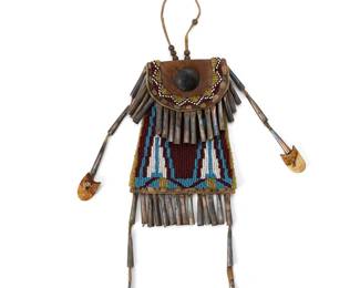 239
A Native American beaded hide strike-a-lite bag
Late 19th/early 20th century
The hide flap-front bag for carrying fire-starting flint, adorned with beads depicting a floral motif and featuring tin cone fringes, two terminating in metals bells
Without fringe: 5.75" H x 4.25" W x 1.25" D
Estimate: $400 - $600
