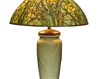 46
A Rookwood pottery table lamp and daffodil shade
1941
Marked for Rookwood; further marked: XLI / 6045
The converted celadon porcelain vase fitted with patinated metal components for a two-light lamp, surmounted by a daffodil pattern leaded glass shade from Paul Crist Studio, electrified
Overall: 22" H x 16" Dia.; Shade: 6.5" H x 16" Dia.; Lamp: 21.75" H x 6.25" Dia.
Estimate: $1,500 - $2,000