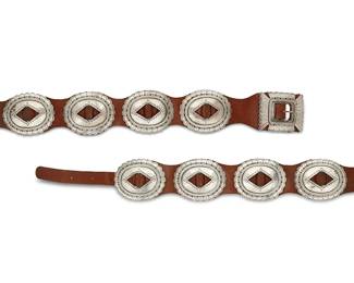268
A Navajo First-Phase-style silver concho belt
Mid-20th century
Unmarked
A heavy belt featuring a rectangular stamped and chased sterling silver buckle with eight large stamped sterling silver oval conchos mounted with a narrow brown leather strap to a wider shaped brown leather strap
Buckle: 2 3/4" H x 3 3/8" W; each concho: 3 1/8" H x 3 3/4" W; belt: 43 1/4" L x 2 7/8 " H
588.6 grams gross
Estimate: $800 - $1,200