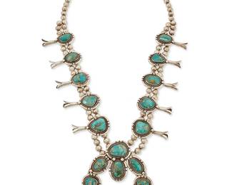 303
A Southwest silver and turquoise squash blossom necklace
Mid/late 20th century
Unmarked
Featuring a chunky sterling silver and set turquoise naja with rope wire and silver ball accents with ten matching blossoms, all suspended from a double strand of silver beads
25" L x 3 1/4" H
175.8 grams gross
Estimate: $600 - $800